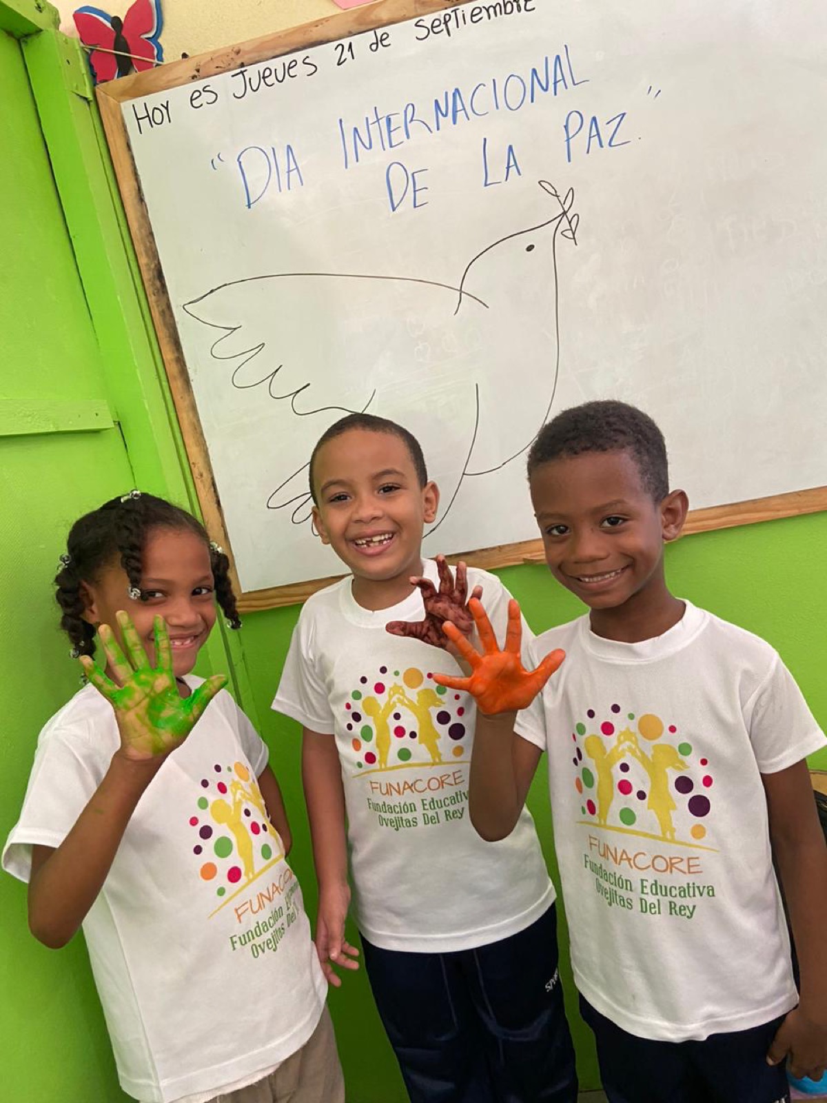 Niños con la camiseta de FUNACORE y las manos pintadas de colores