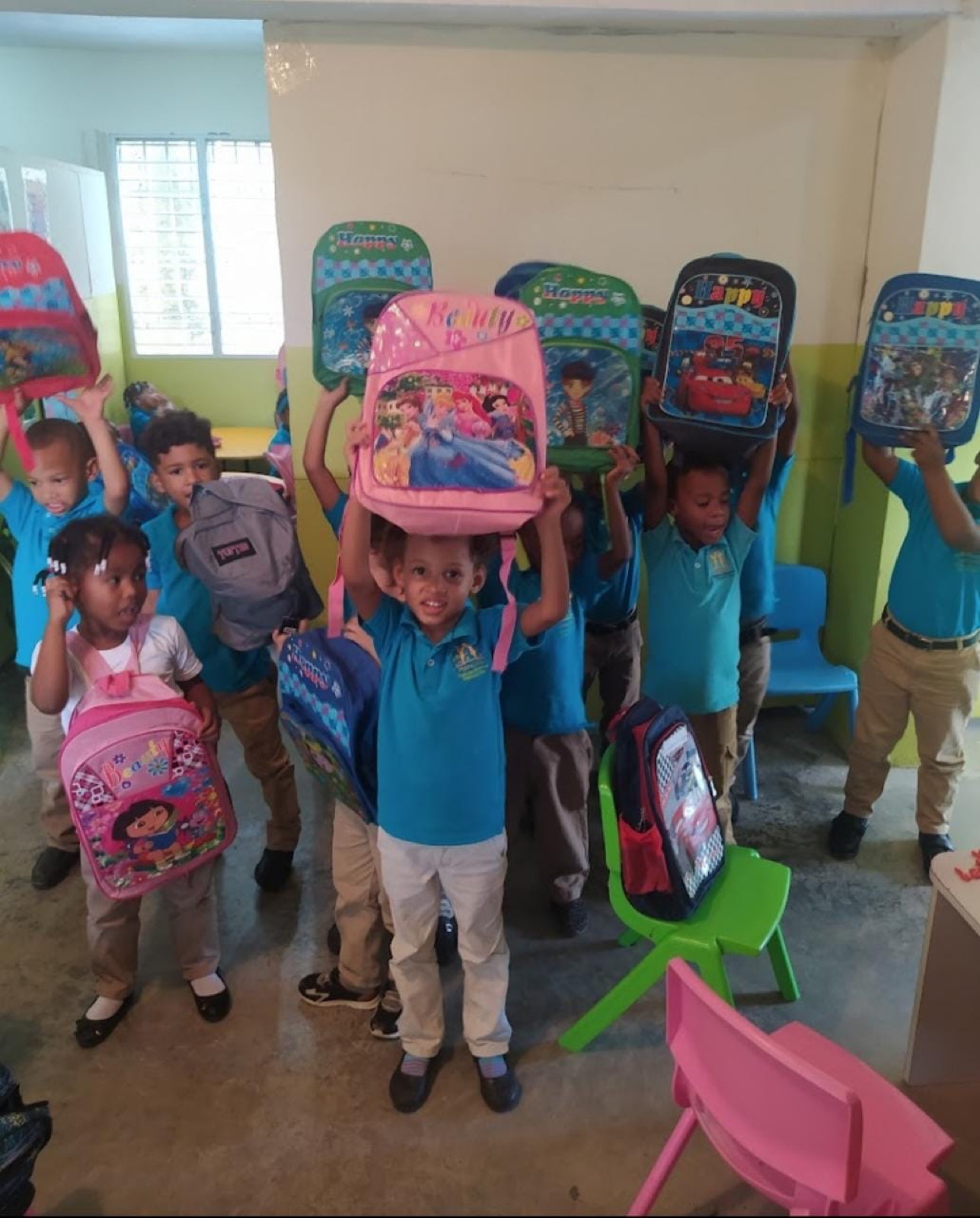 Niños de preescolar celebrando con sus mochilas nuevas